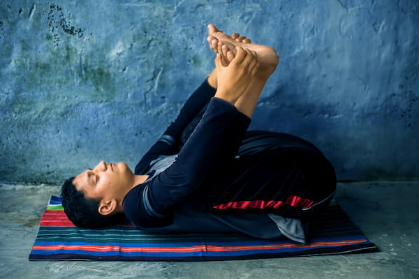 Jeune homme en posture de Viniyoga, les yeux fermés et le visage détendu | yoga en ligne et cours de yoga - France, Suisse, Belgique, Québec, Canada | Liance